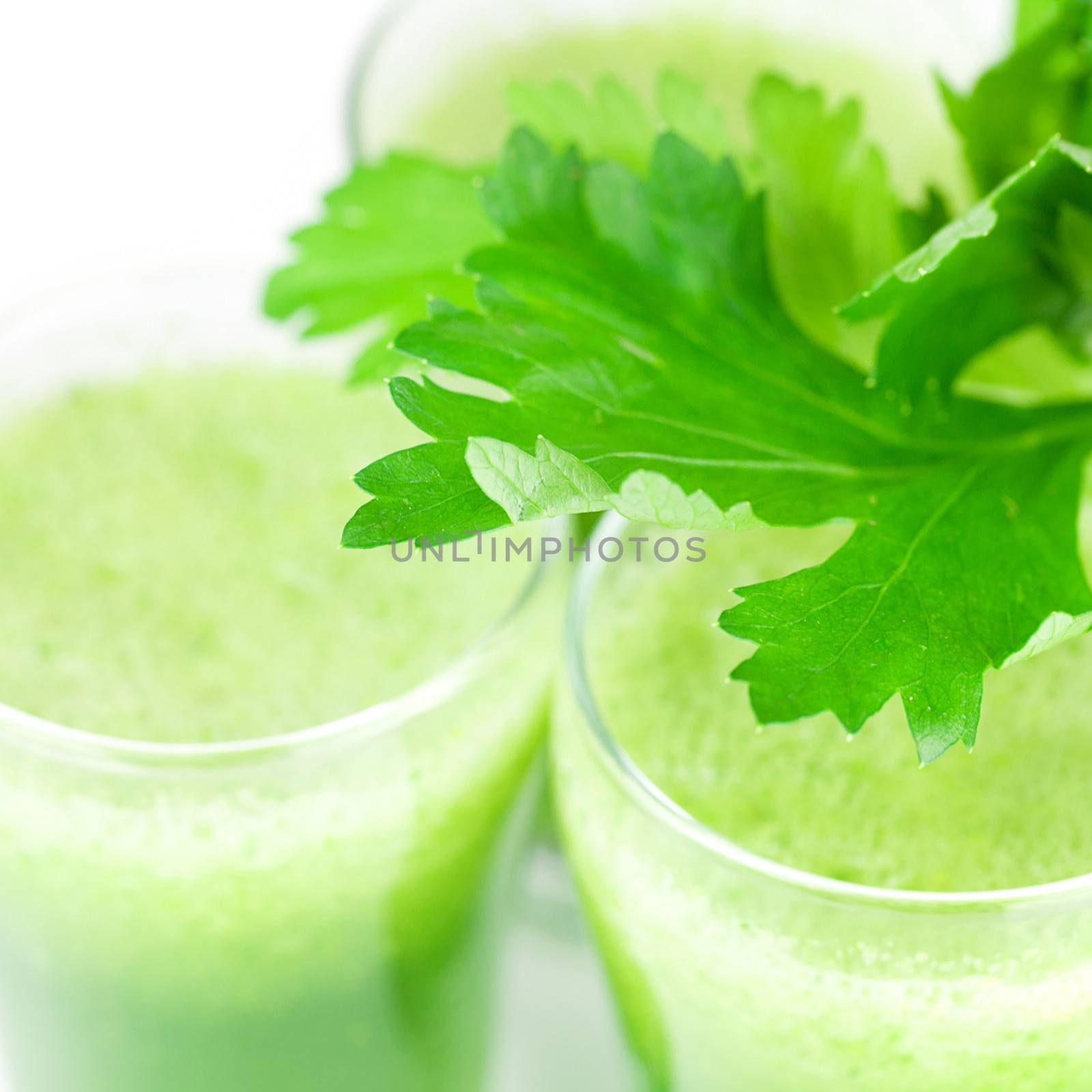 celery and three glasses with celery juice isolated on white by jannyjus