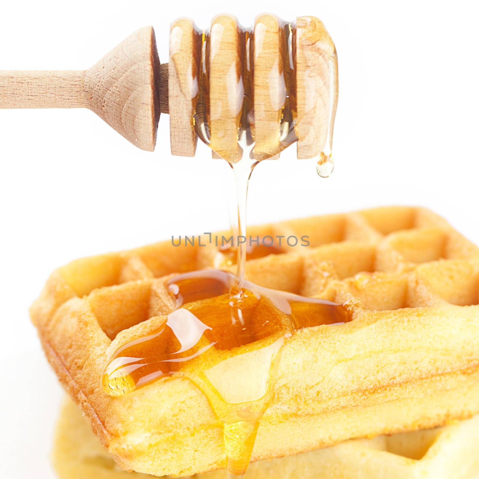 Belgian waffles on a plate, stick for honey and honey isolated o by jannyjus