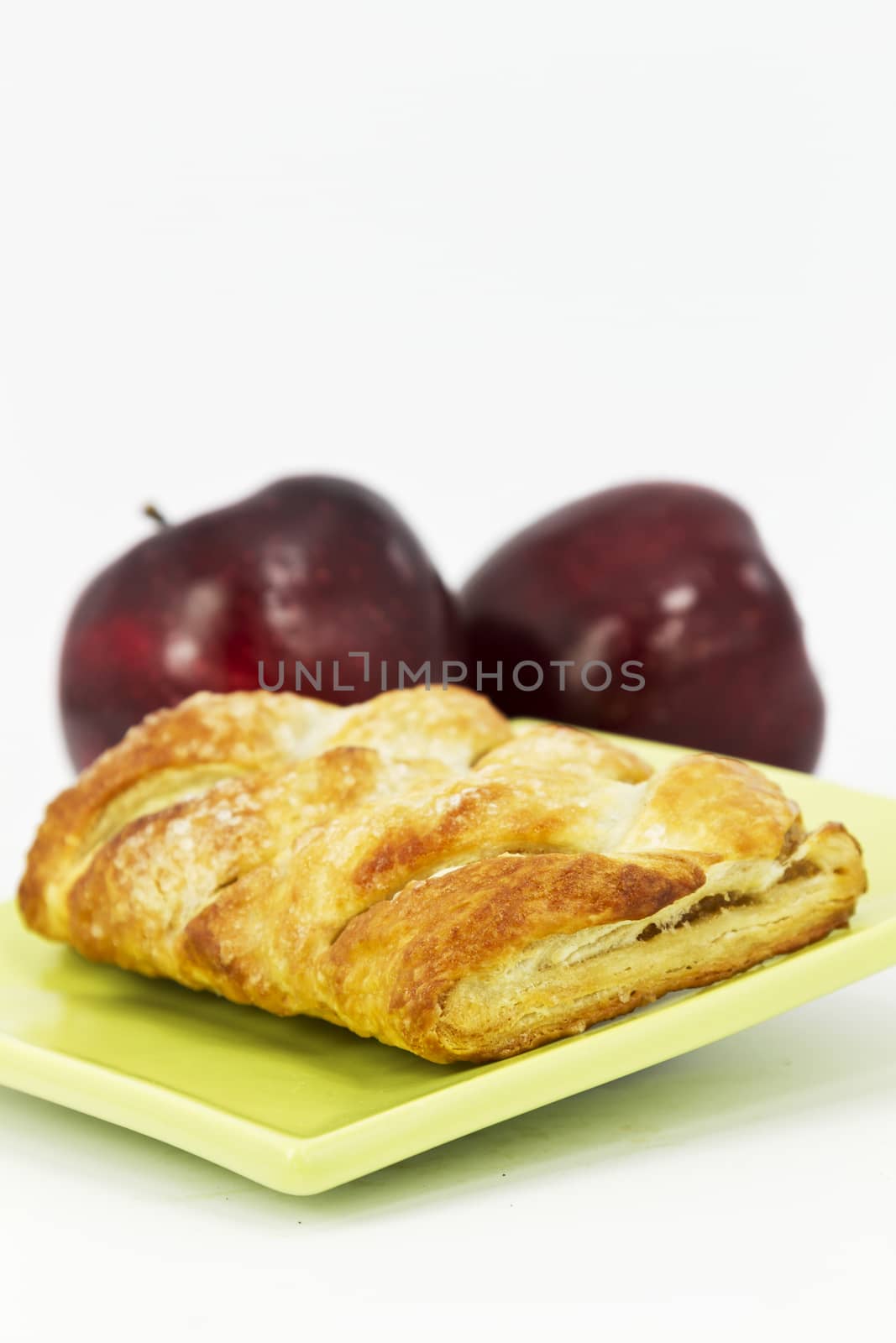 Selective focus on flakey, freshly baked apple strudel placed on modern, green, square 