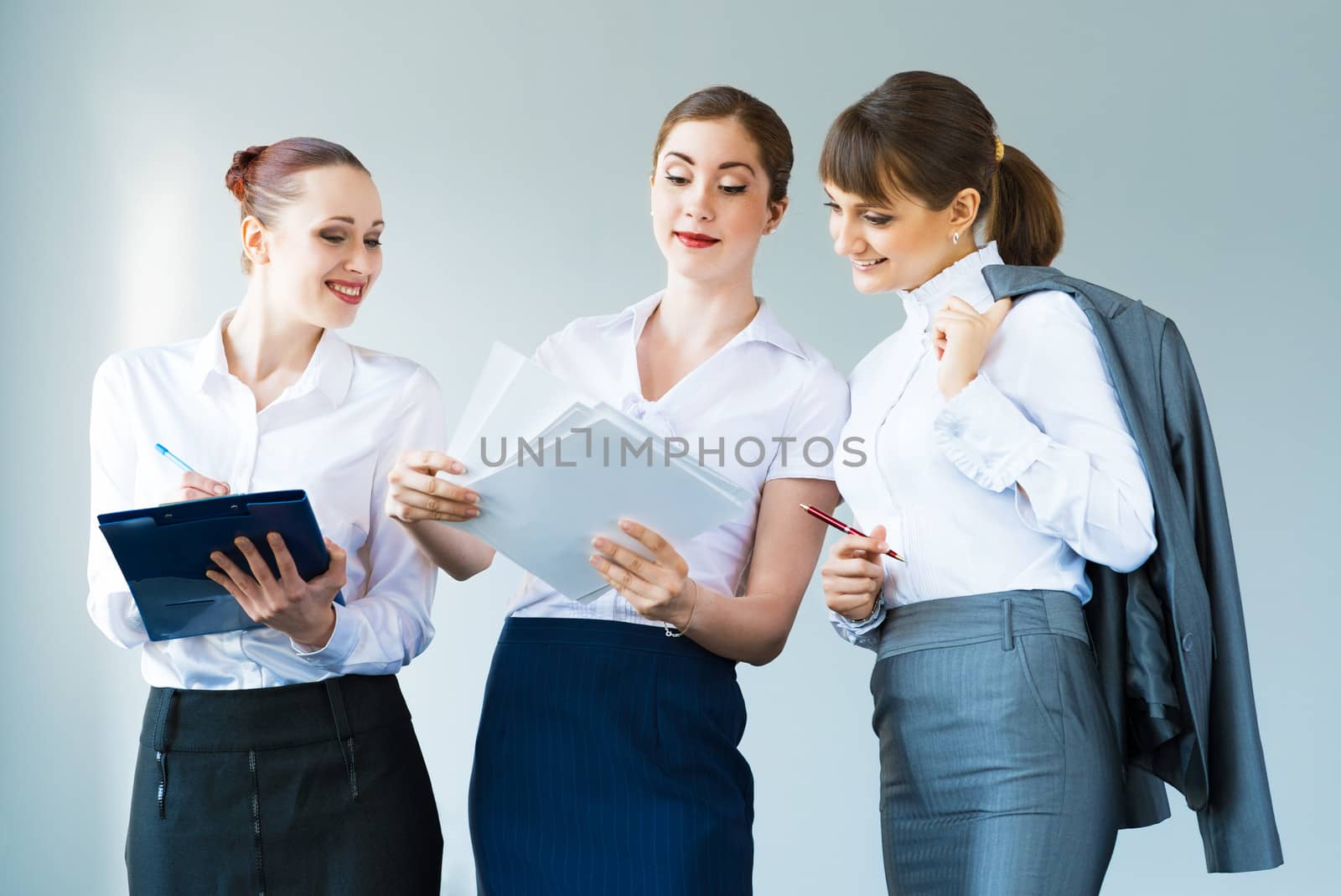 group of business women discussing documents together, teamwork in business