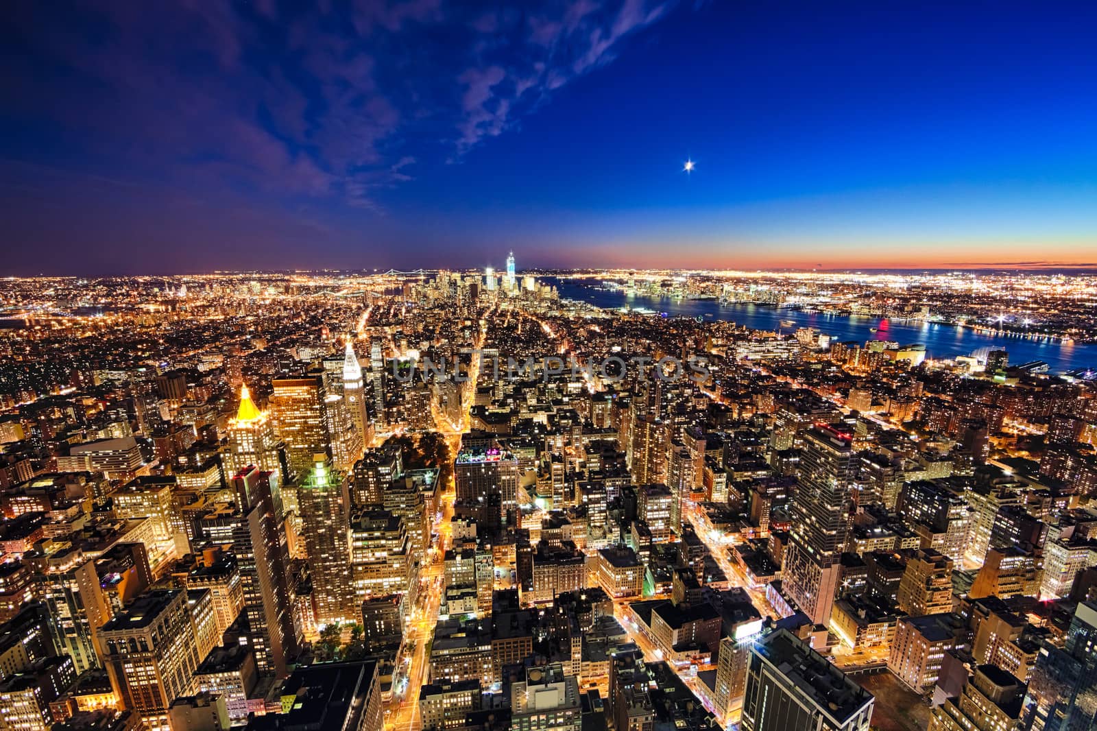 New York City and New Jersey skyline at night w the Freedom tower and Brooklyn bridge