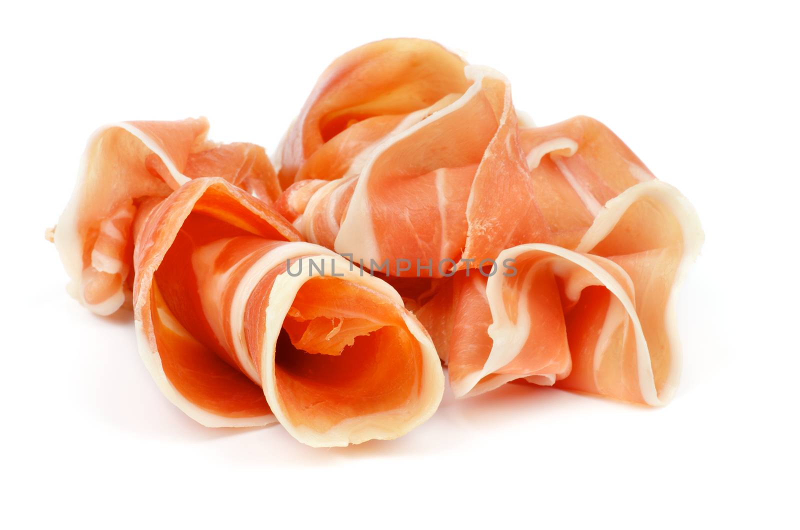 Curled Slices of Delicious Prosciutto isolated on white background