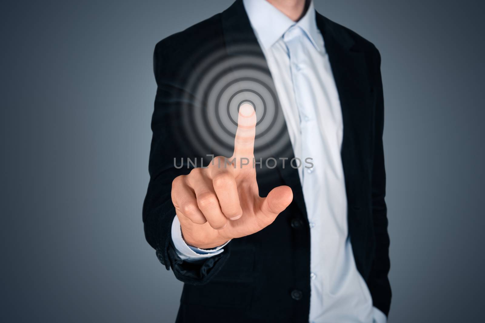 Portrait of business person touching button on invisible screen. Touch screen concept image. Isolated on dark gray background. 