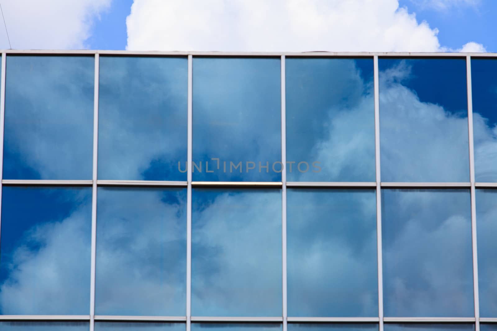 blue sky reflected in modern building mirror glass wall by thanomphong