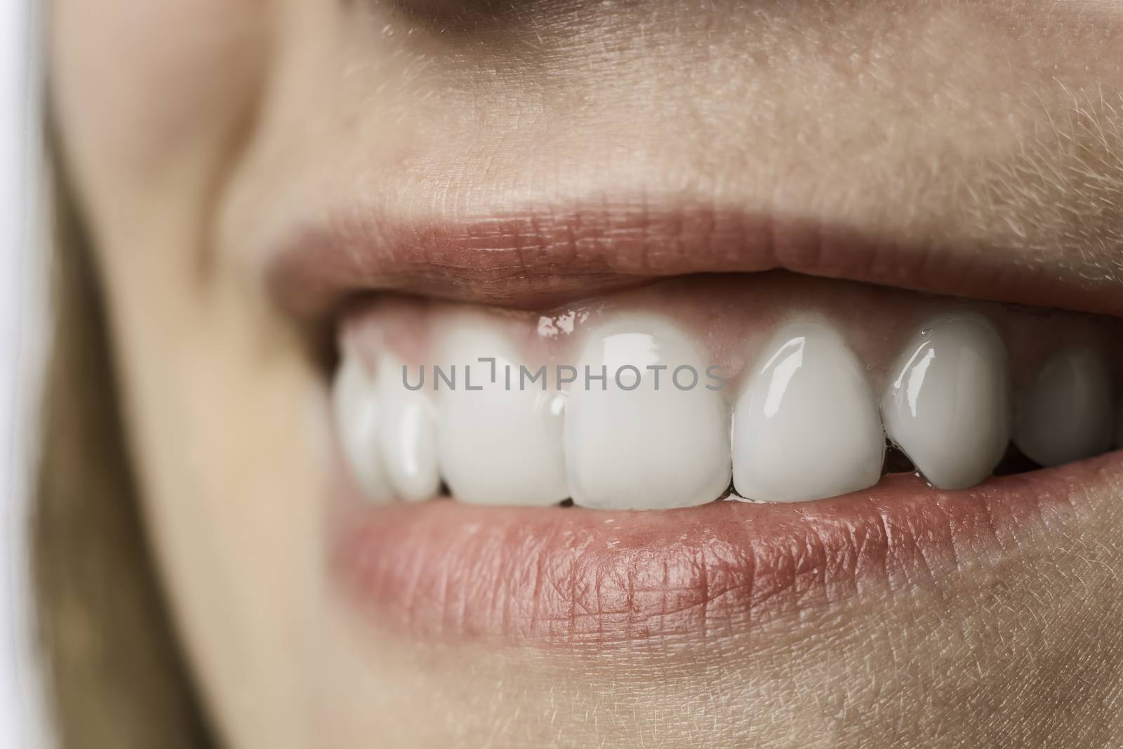 Closeup of the white teeth of a young woman with red lips