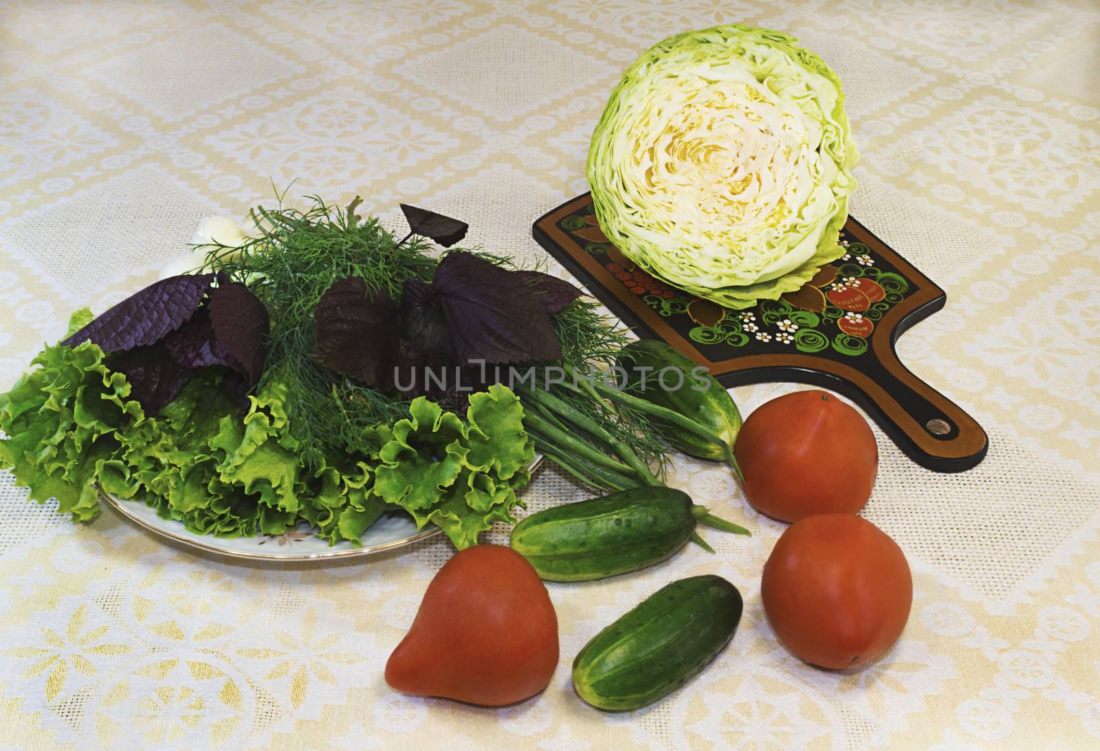 Lettuce, dill, onions on a white plate and vegetables ( tomatoes, cucumbers, cabbage).
