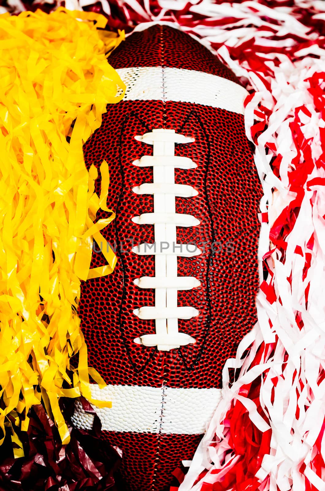 Closeup of American football and pom poms.