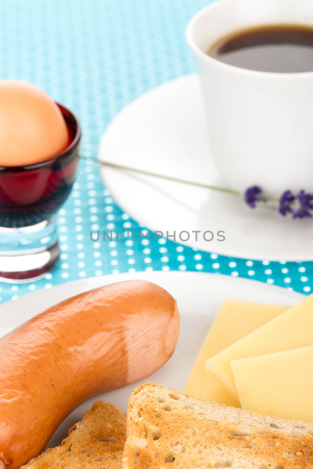 Breakfast with toast, cheese, sausage, egg and cup of coffee.