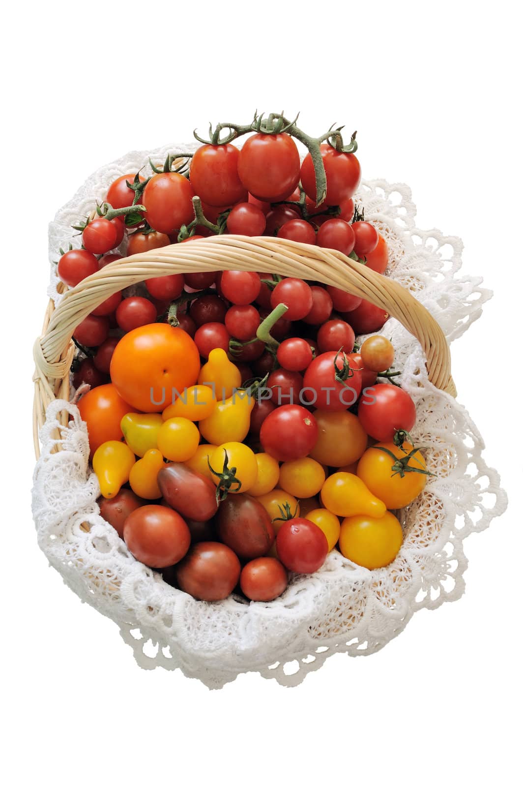 Different varieties of tomatoes in a basket on a white background
