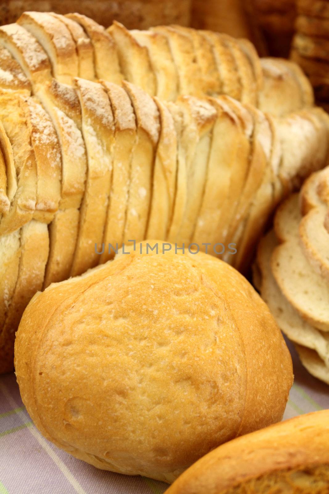 Background of a bread roll against sliced white bread showing textures.