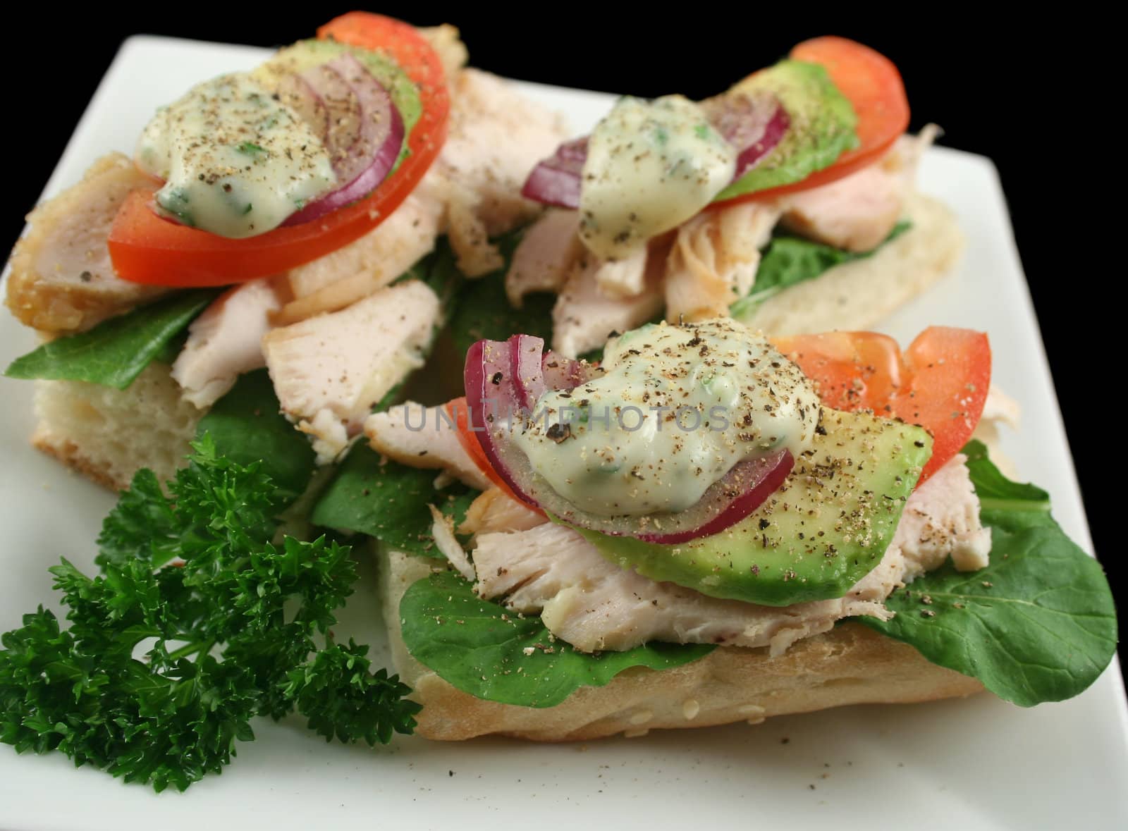 Fresh open chicken finger sandwiches with avocado red onion and mayo with lettuce