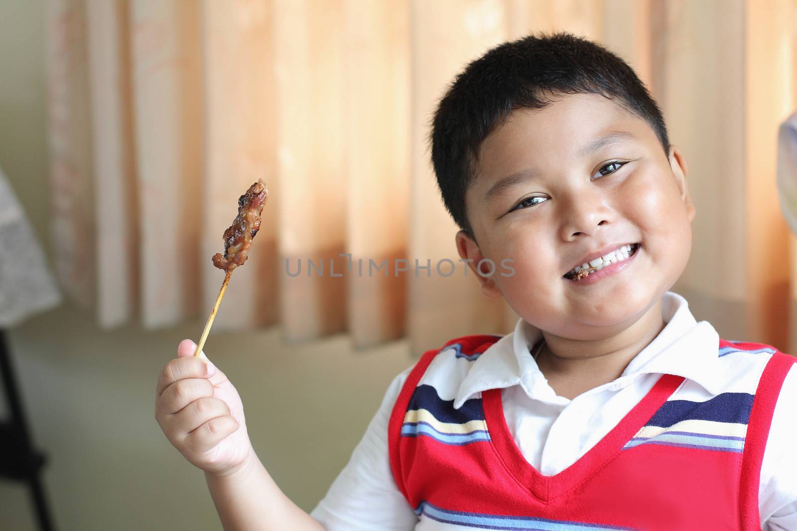 The boy eating a delicious pork.