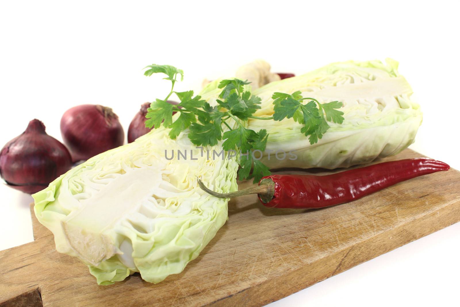 sweetheart cabbage with parsley, garlic  and onions on a light background