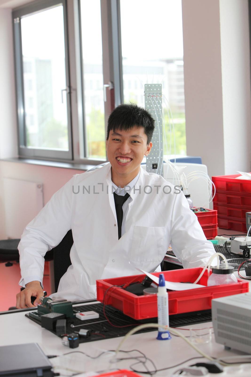 Smiling Asian man working in a laboratory by Farina6000