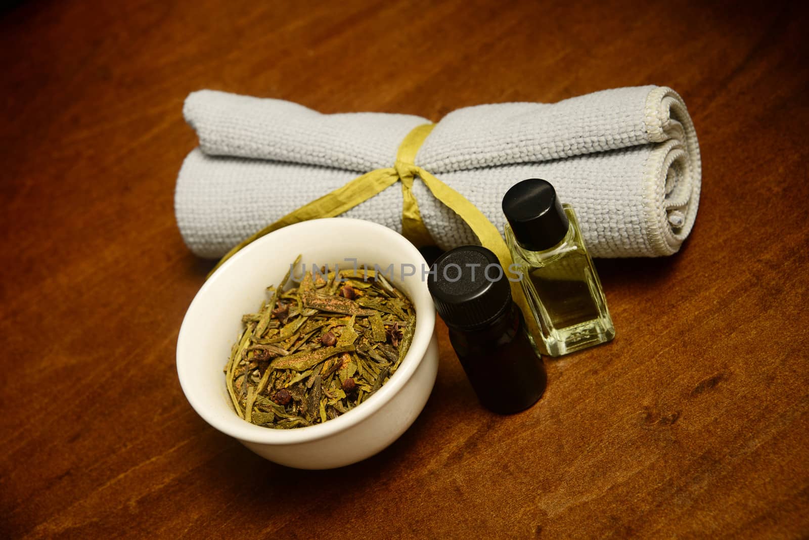 two bottles of essential oil with herbs and wash cloth for beauty treatment at spa