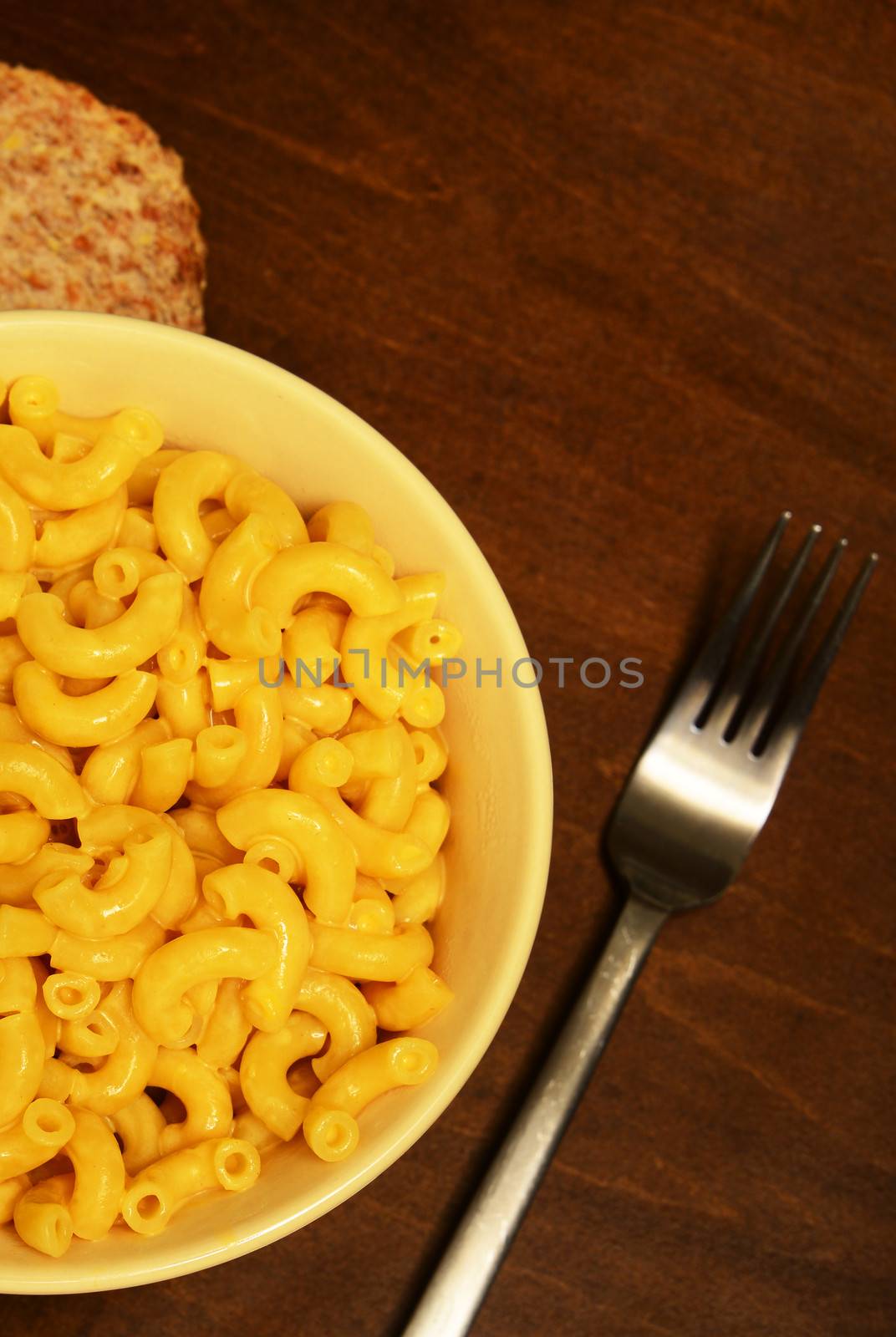 mac and cheese for meal with fork on wooden table 