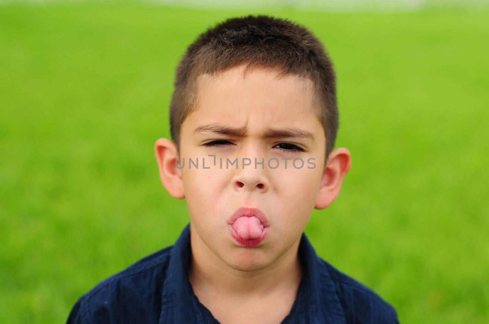 Naughty young child sticking out his tongue 