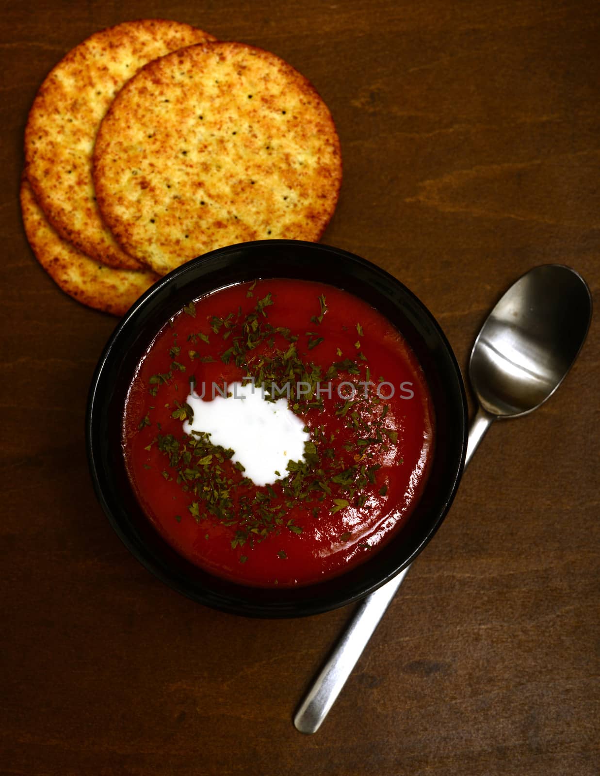 tomato soup with whole grain crackers on a dark wood background