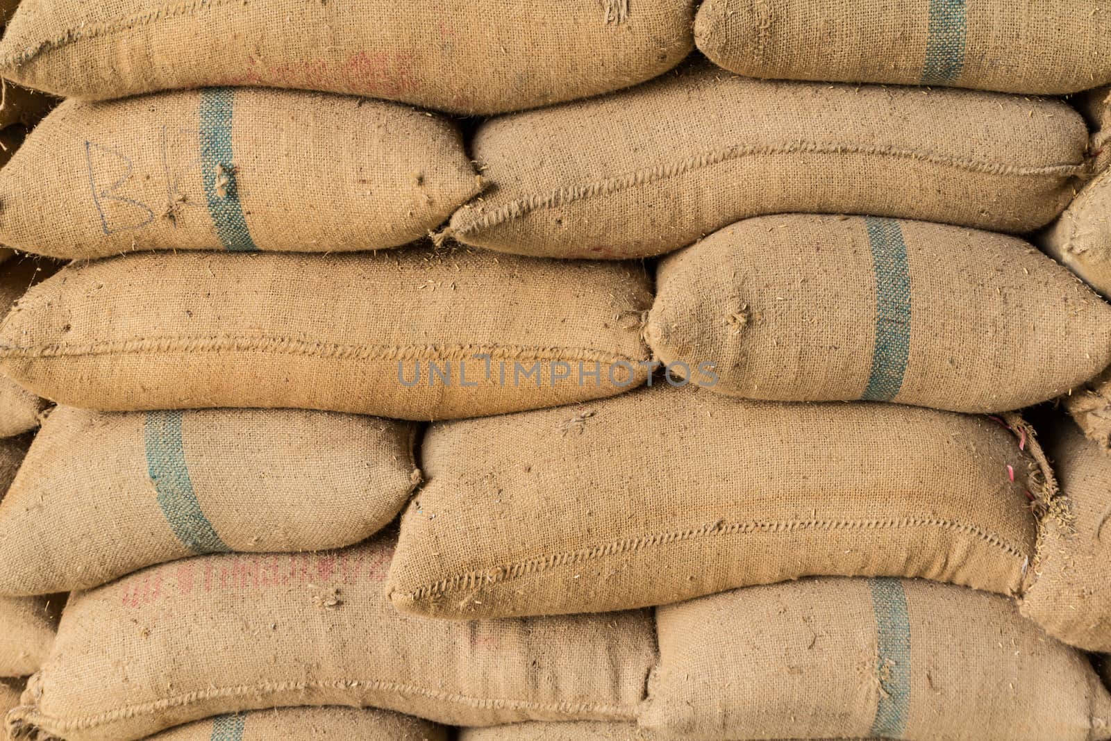 Old hemp sacks containing rice placed profoundly stacked