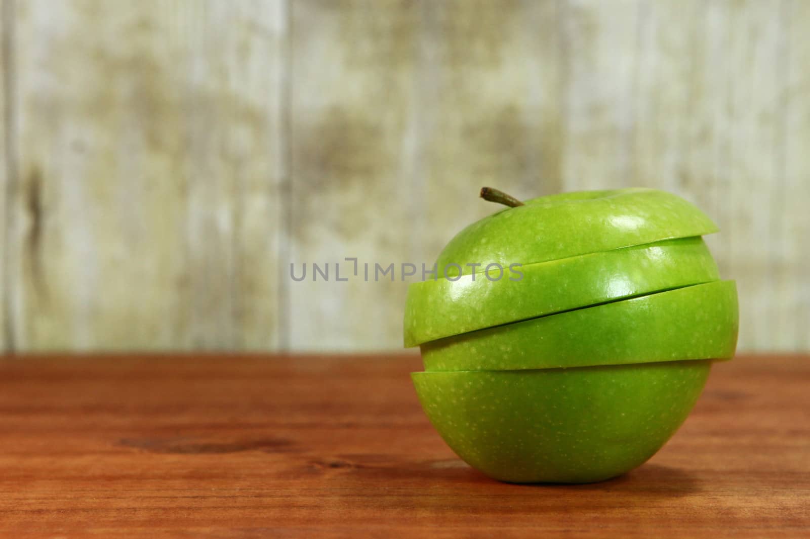 Green Apple Fruit Sliced Sitting on a Wooden Surface