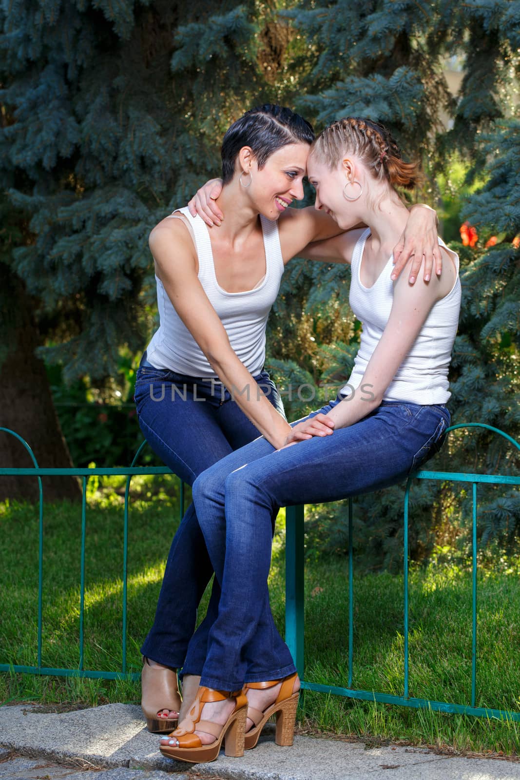 Family, mother and daughter are sitting next to each other and look into each other's eyes