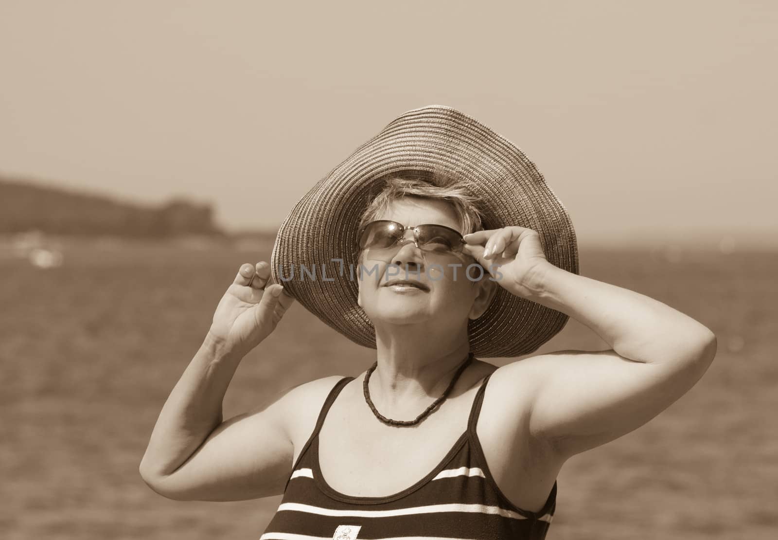A woman in a hat on a background of the sea