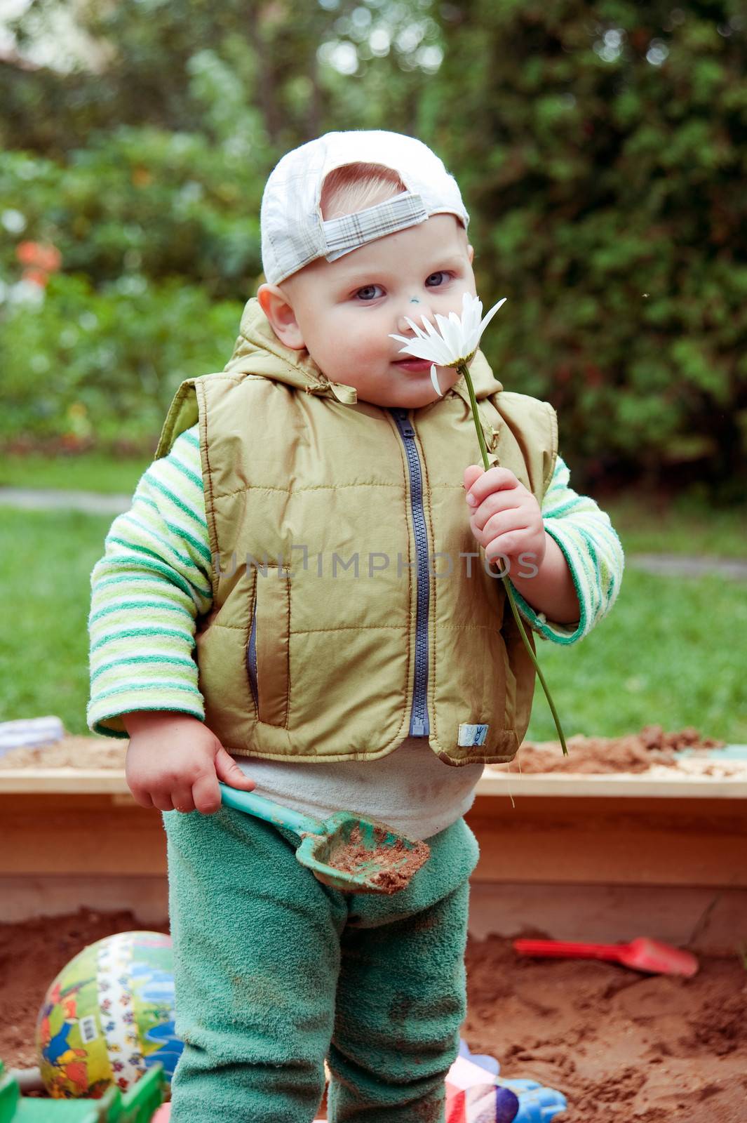 working boy playing in a sandbox with a car