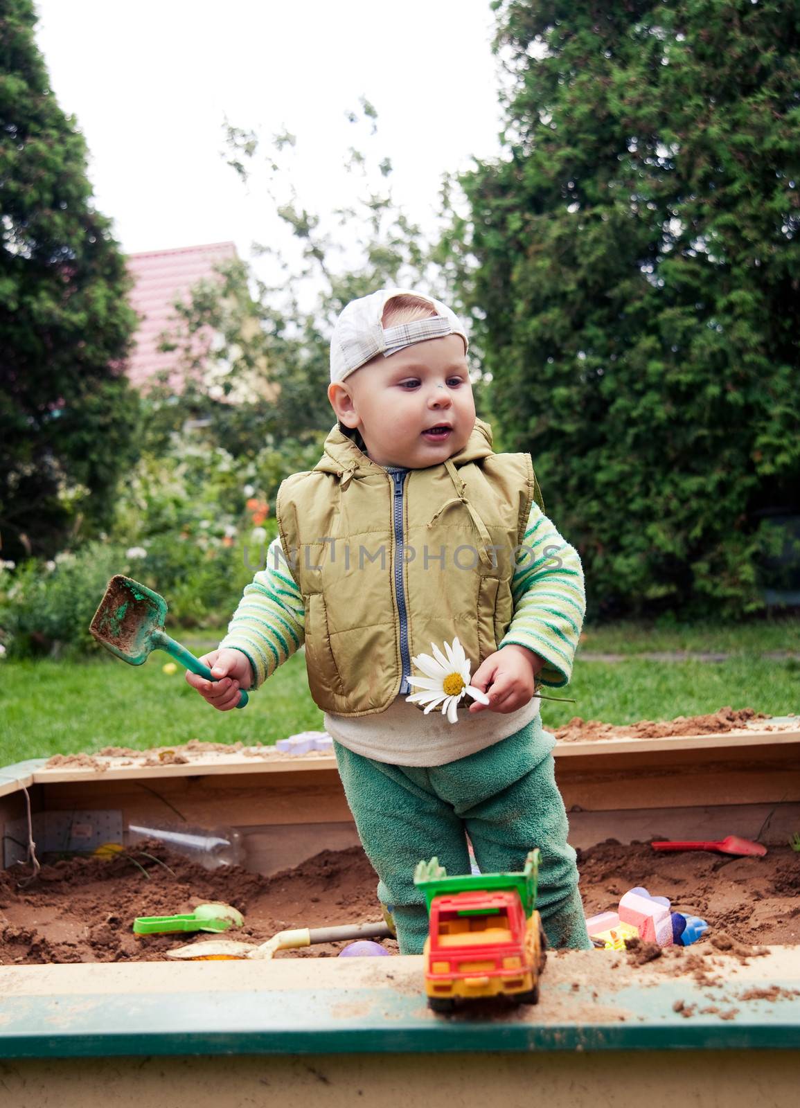 working boy playing in a sandbox with a car