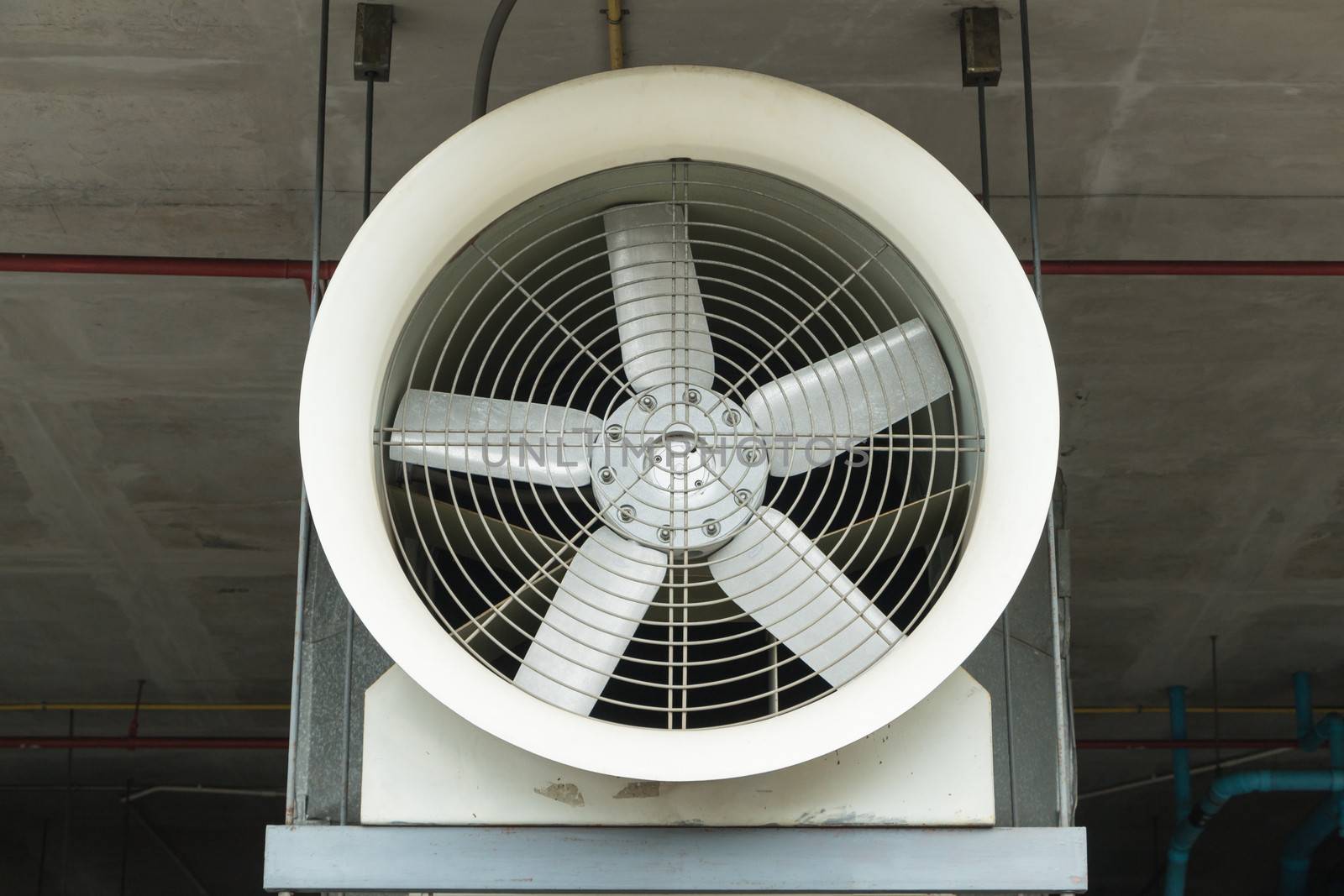 Industrial fan behind a metal grate.