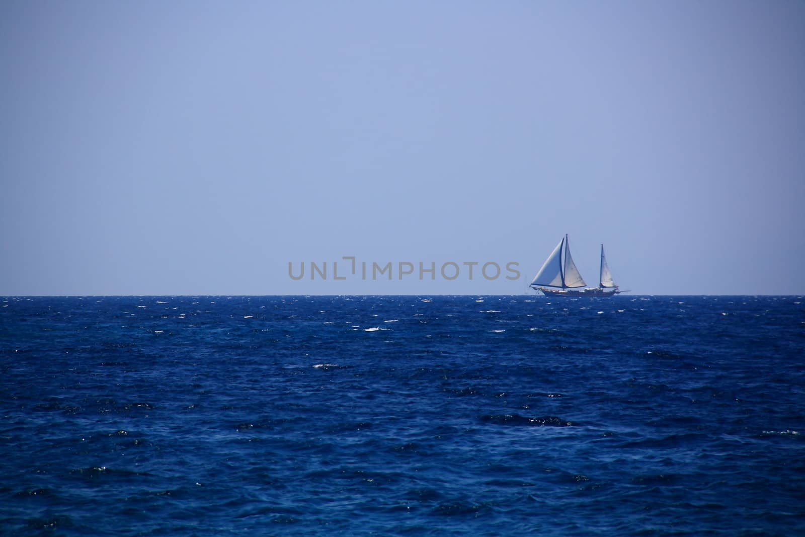 lonely yacht sailing in deep blue sea