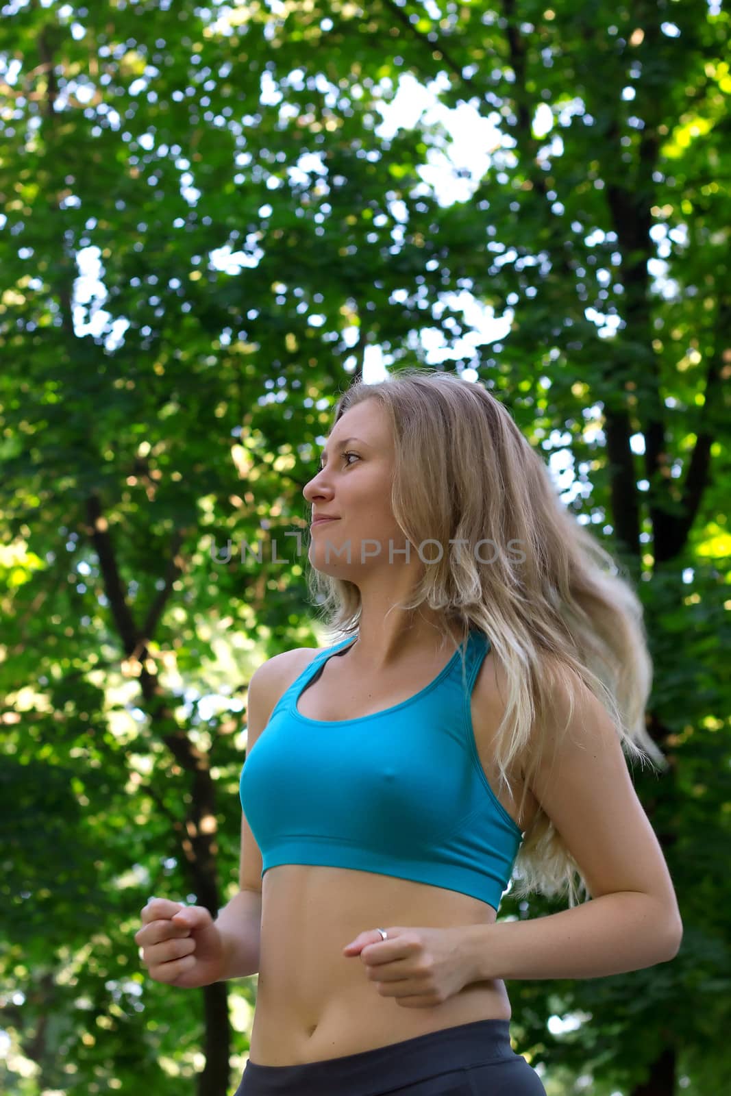 Girl running in the park along trees