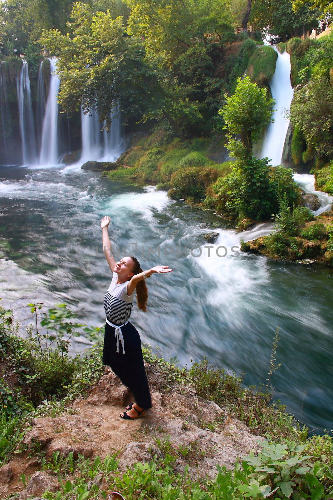 girl in waterfall enjoying life with mountain and waterfall view
