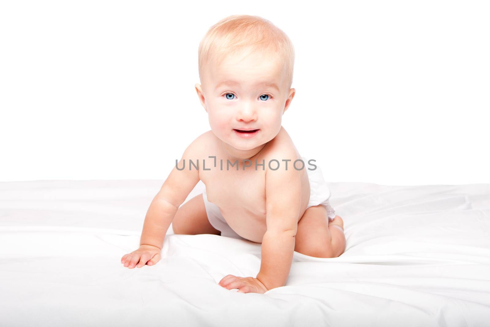 Cute adorable happy crawling baby infant with blue eyes in diapers, on white.