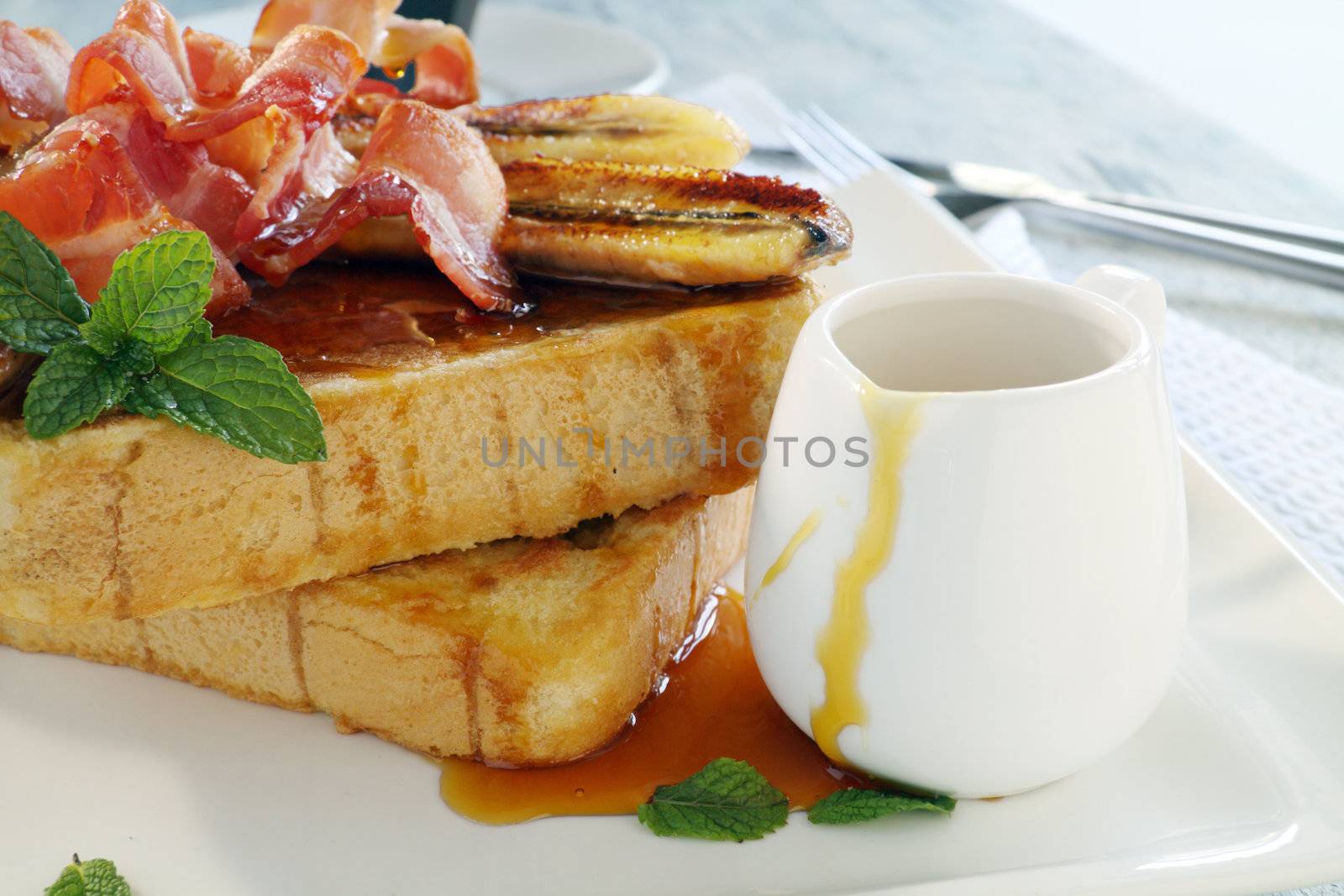 French toast with bacon and caramalized banana with maple syrup.
