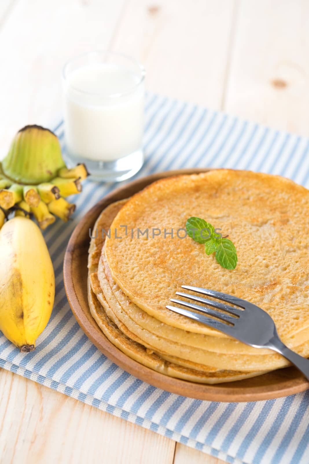 Homemade banana pancakes or crepe on dining table.