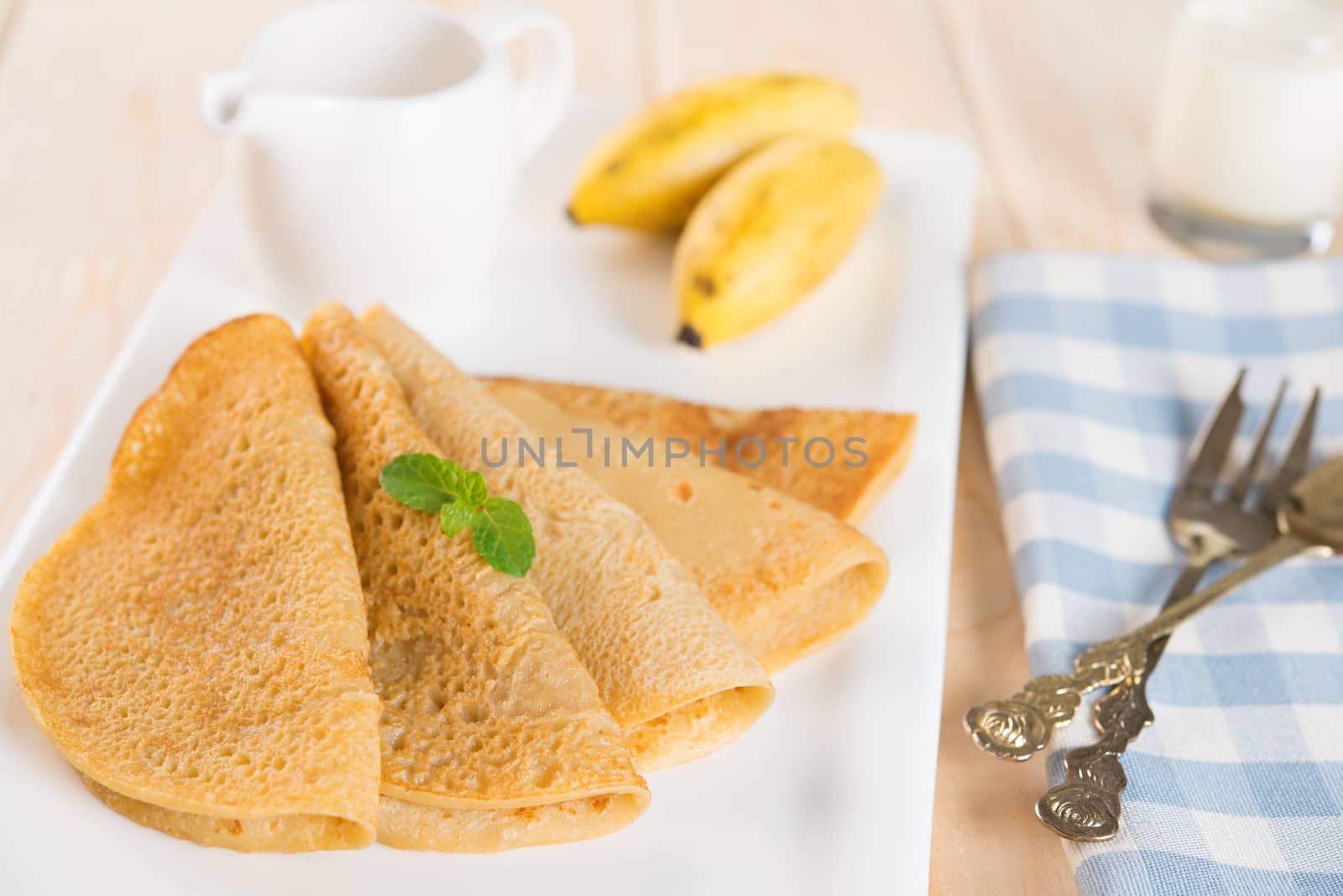 Asian style breakfast homemade banana pancakes or crepe on dining table.