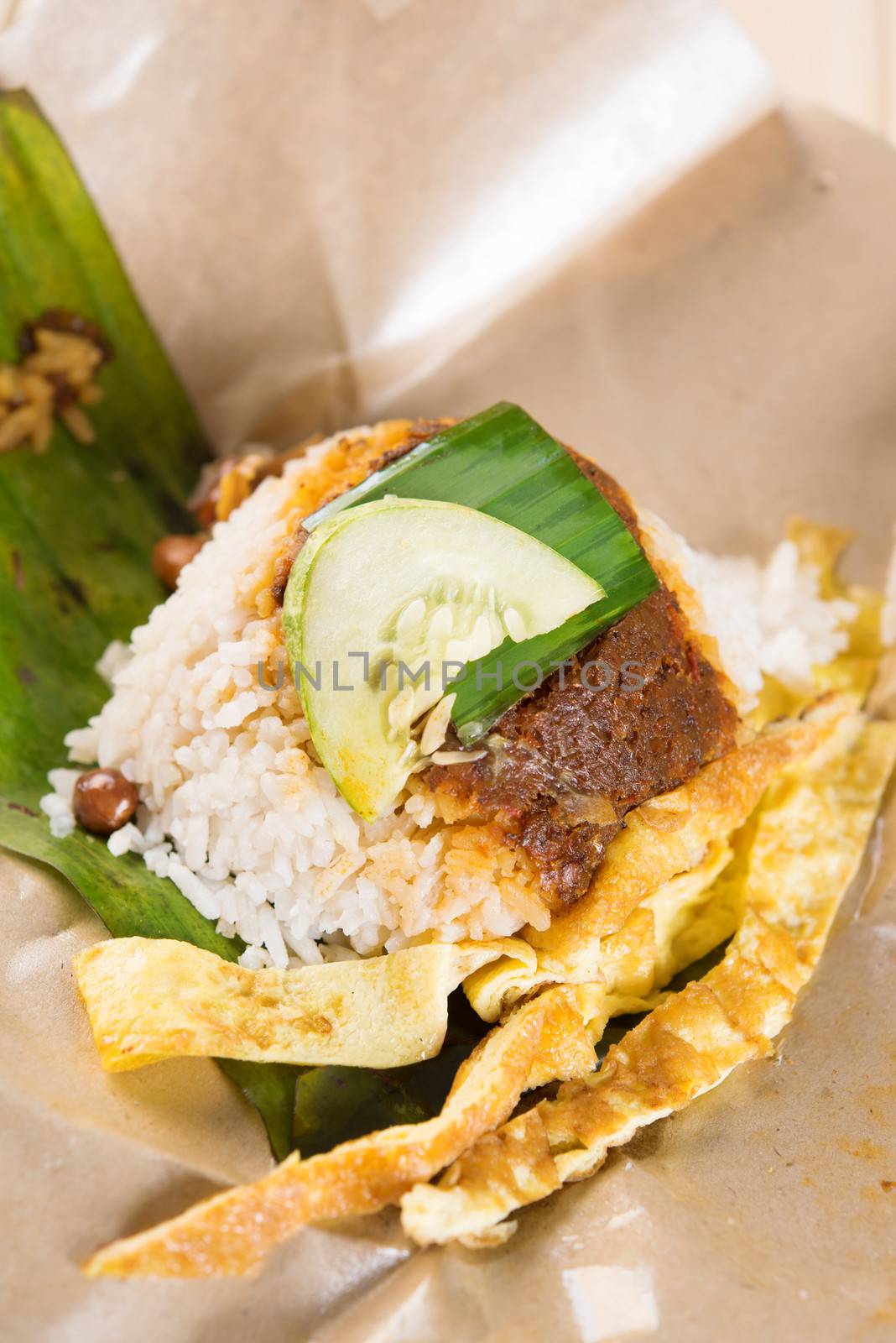A pack of nasi lemak (Malaysia National Dish) on dining table ready to eat.