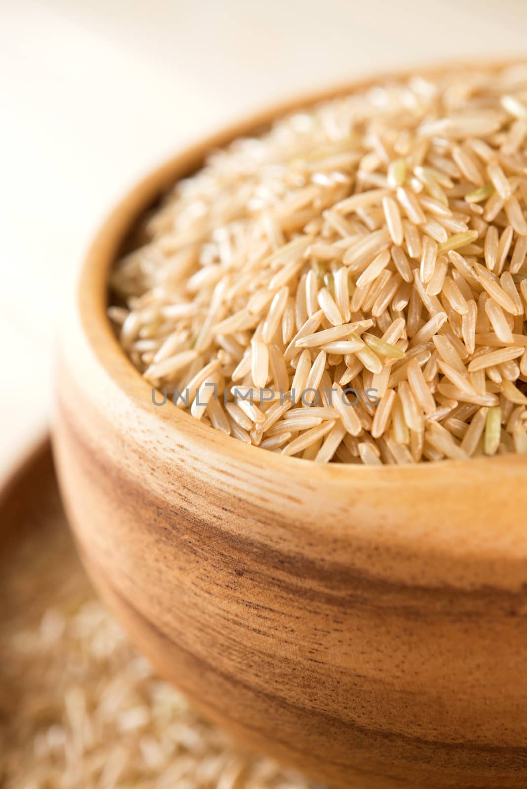 Close up India raw organic basmati brown rice in wooden bowl