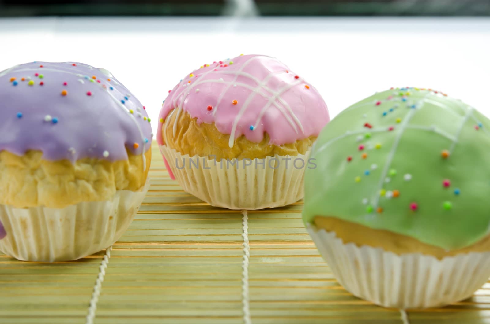 close up  cupcake with colorful sprinkles on wooden board