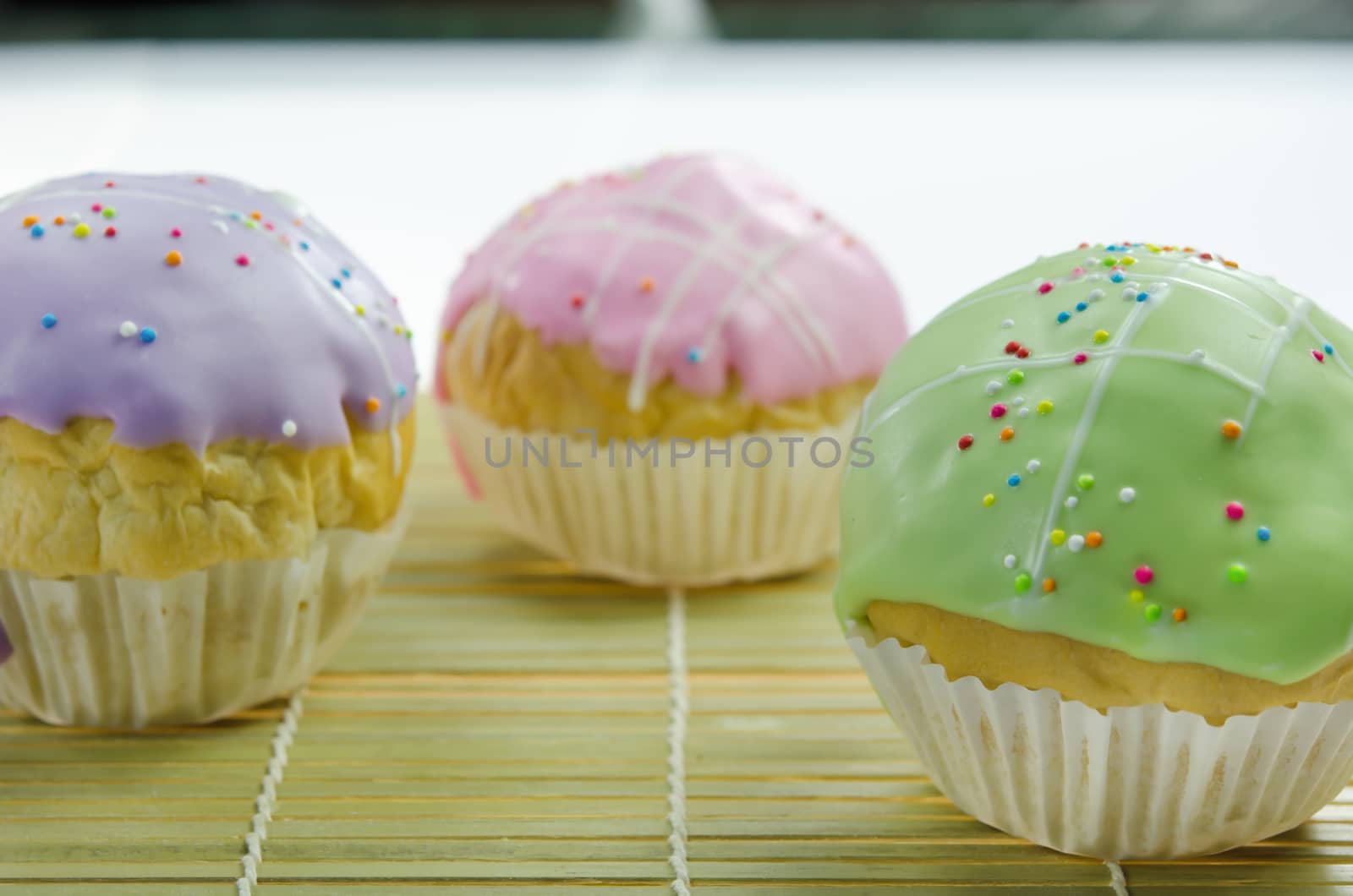 close up sweet  cupcake with colorful sprinkles on wooden board