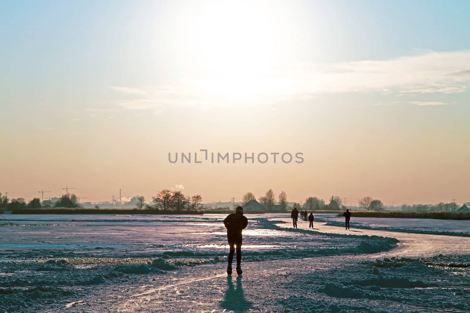 Ice skating in the countryside from the Netherlands at sunset