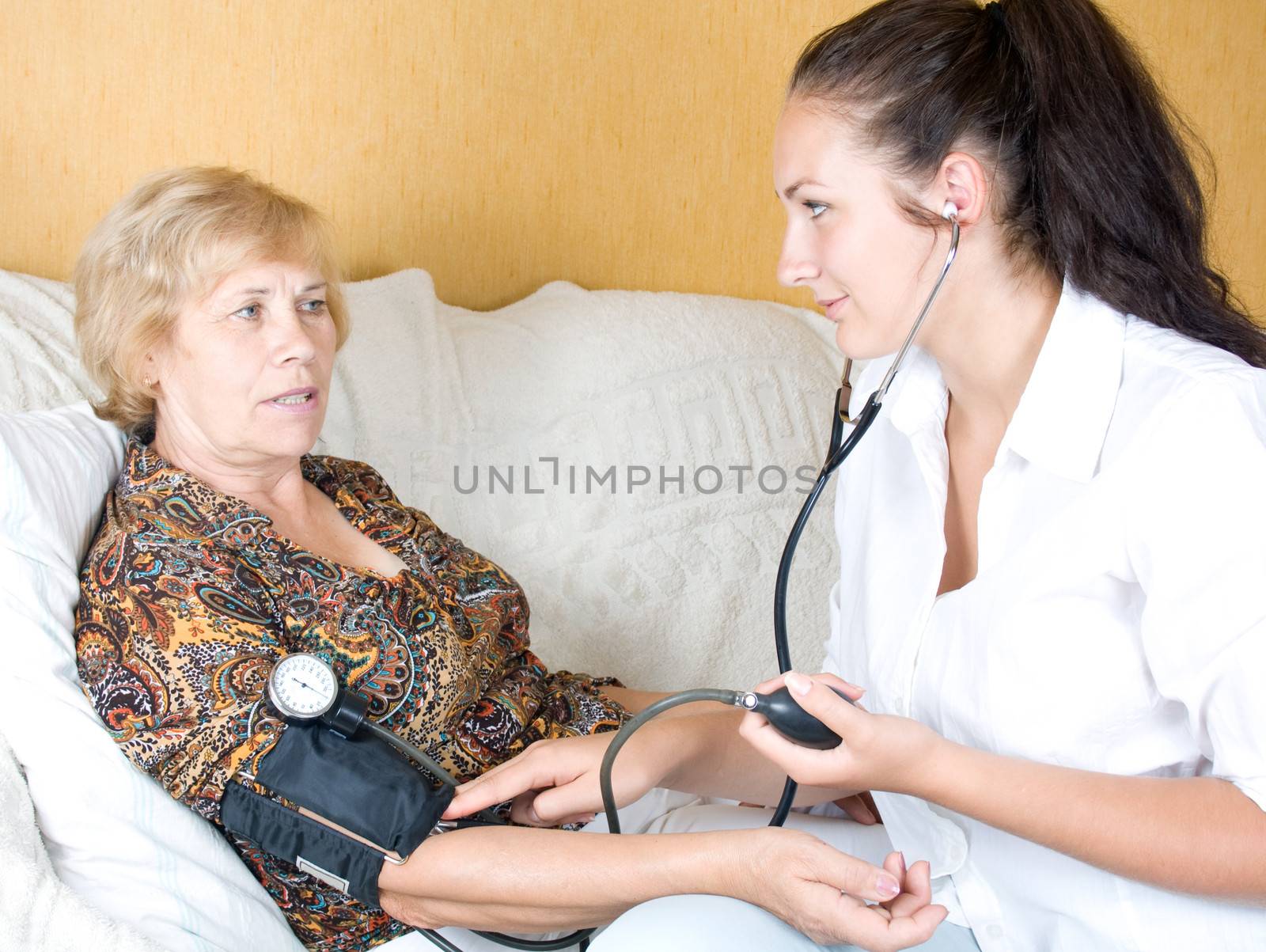 Nurse measures blood pressure of an elderly woman by Irina1977