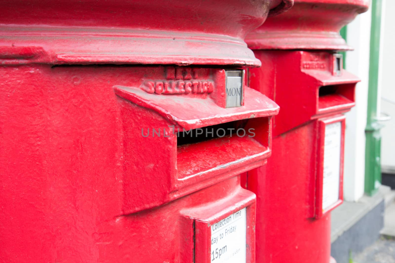 Closeup of two traditional British red mail boxes.