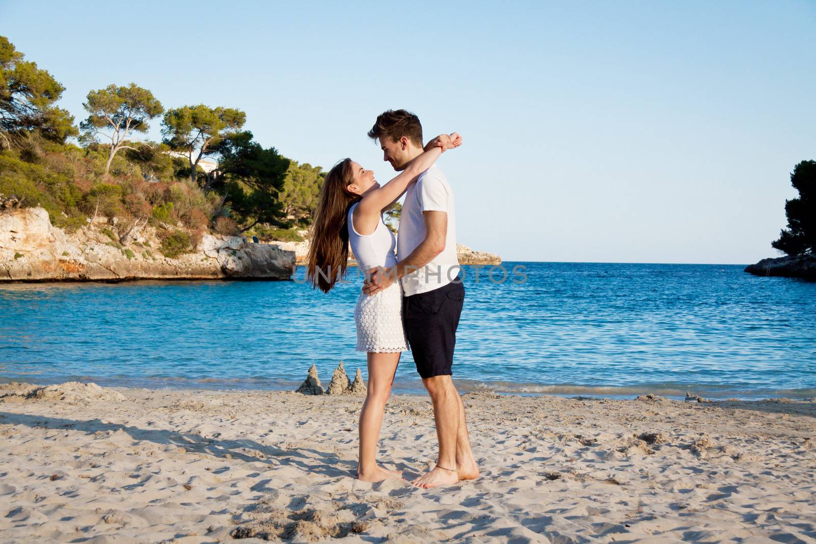 attractive young couple in love summertime on beach smiling romance