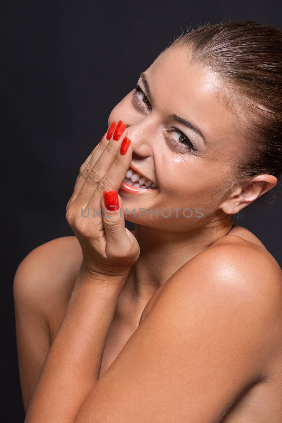 beautiful young woman with orange lipstick and brown eyes on black background