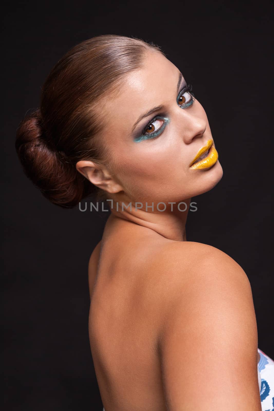 woman with extreme colorfull make up in blue and yellow on black background
