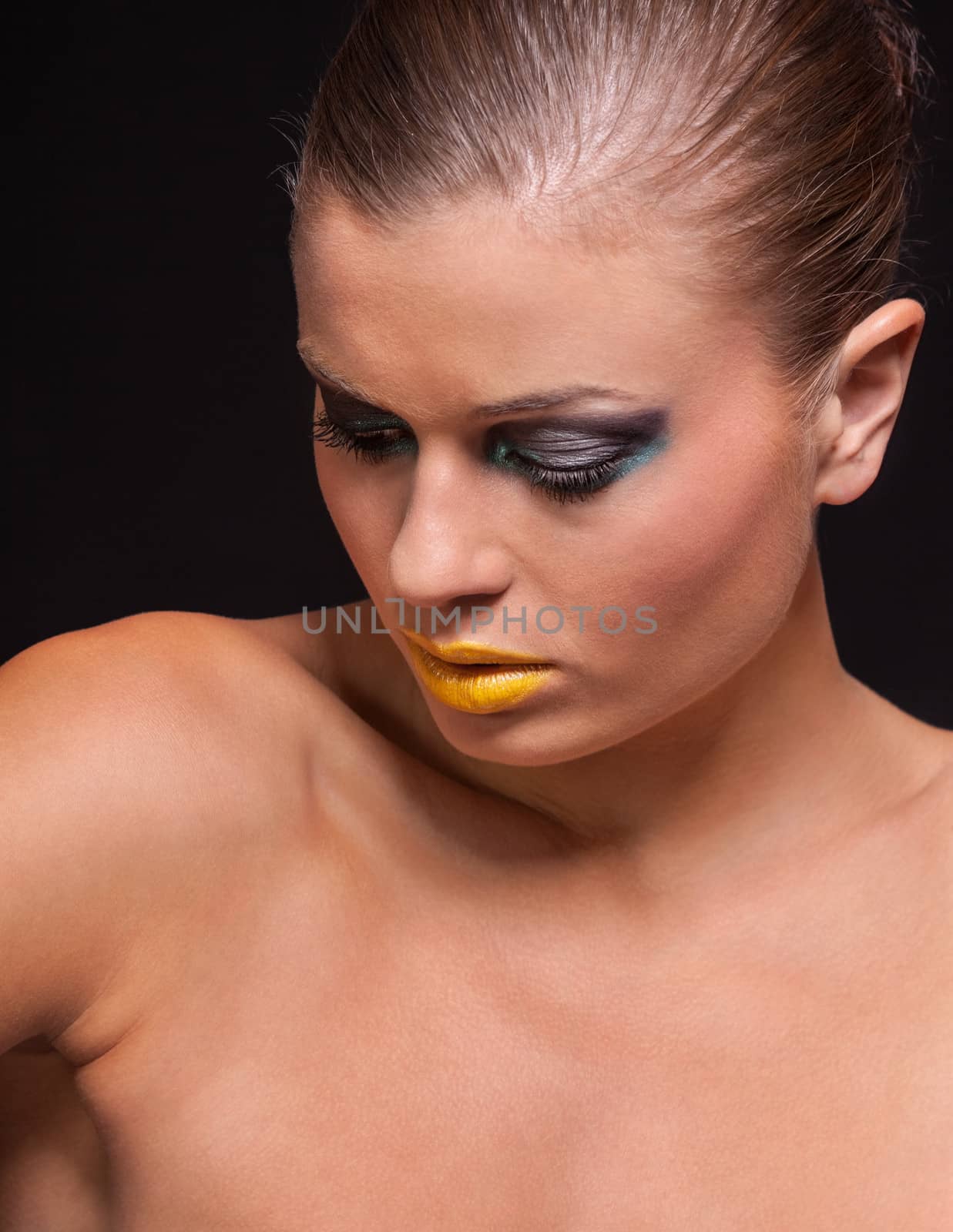 woman with extreme colorfull make up in blue and yellow on black background