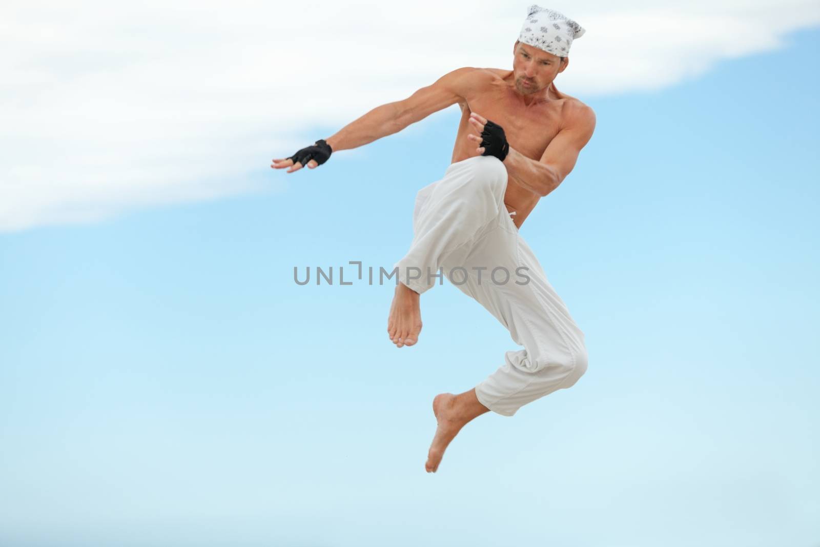 man is jumping sport karate martial arts fight kick jump beach summertime