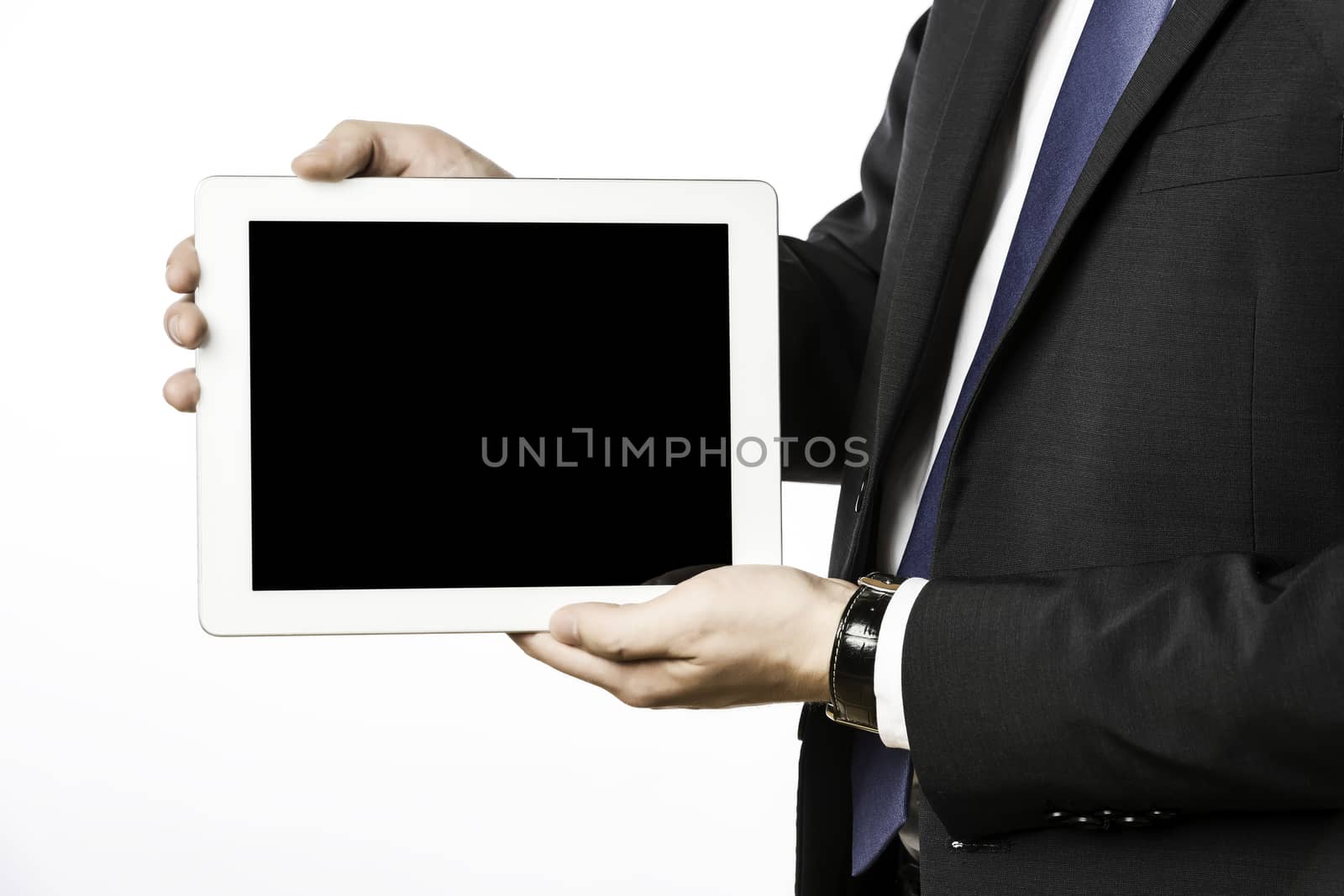 Business man in dark suit with blank tablet computer, isolated on white background