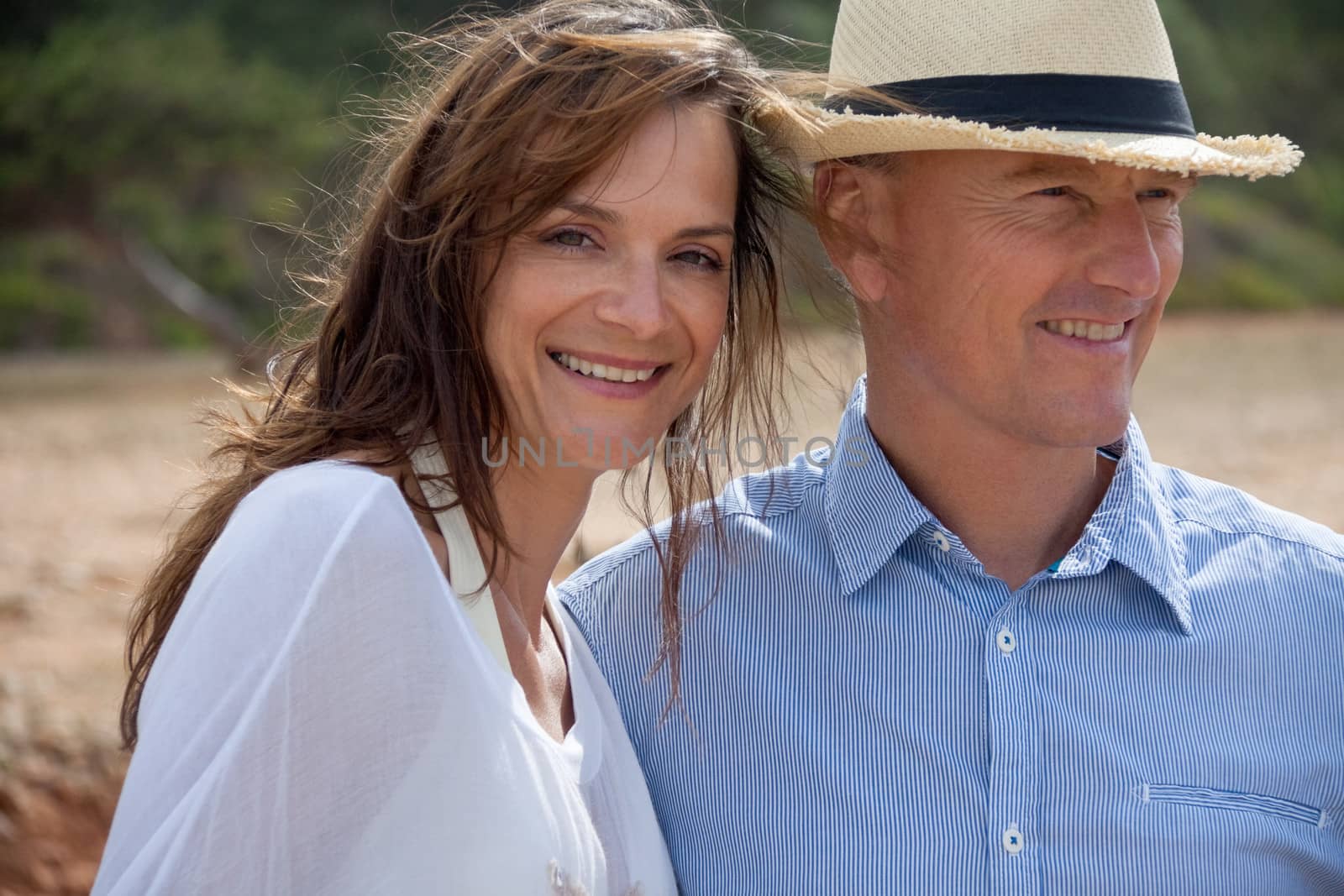 happy adult couple in summertime on beach having fun vacation